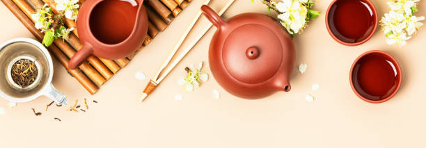 istock Asian Tea set on stone slate board, ceramic teapot, cups, dried tea and spring branches 1317103120