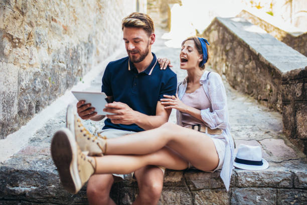 Young tourists couple using a digital tablet in a old town.