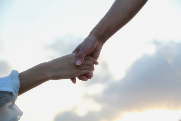 Two hands are almost touching for handshake on white background.