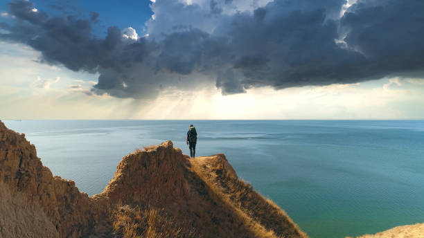 istock The hiker standing on a mountain against the rainy background 1317116652