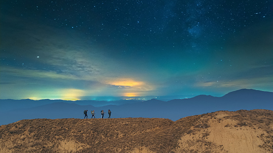 The four hikers walking on the night mountain background