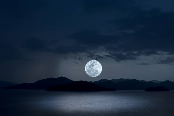 Full moon on sky over lake at night.