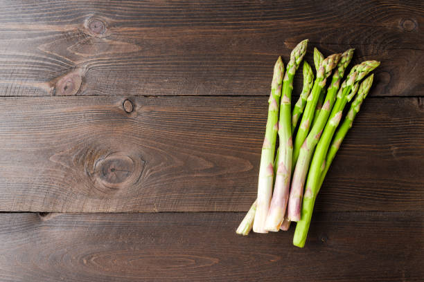 istock Green asparagus on wooden background with copyspace 1317121408