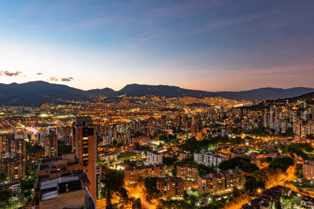 Medellin, Antioquia, Colombia. Colorful sunset seen from El Poblado. Illuminated buildings and mountains.