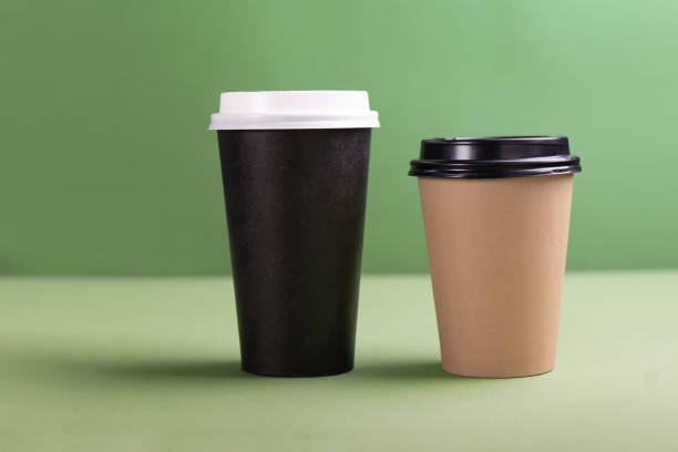istock Two paper cups of coffee or tea on green background 1317123392