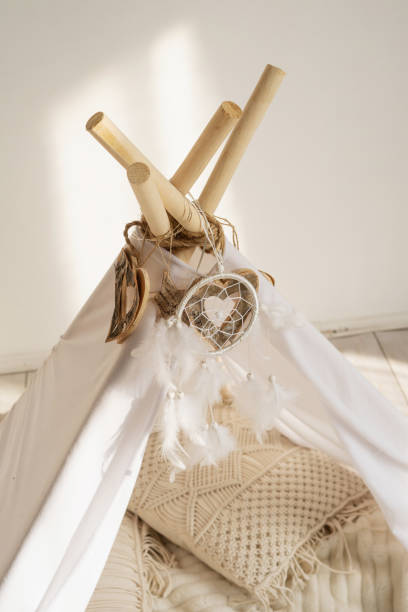 istock White fabric tepee top with decorative wood hearts and white feathers dream catcher. 1317124024