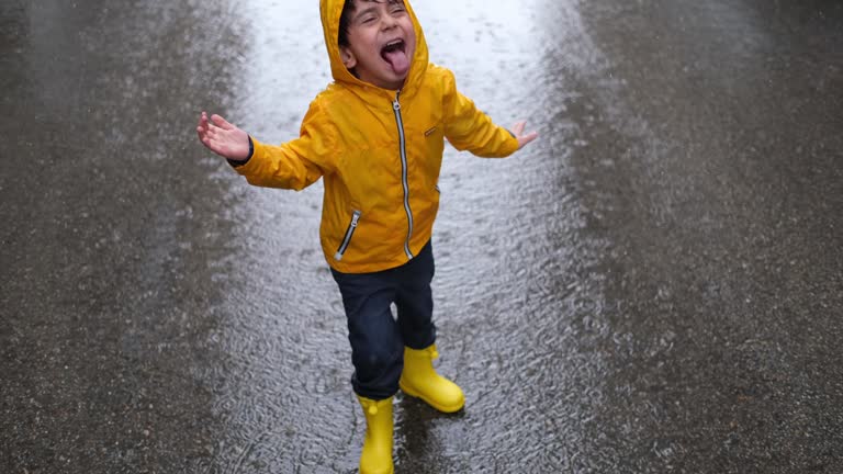 Adorable little boy playing at rainy day