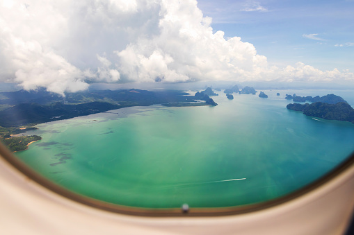 Looking out the window of a plane to the tropical sea. Time to travel.