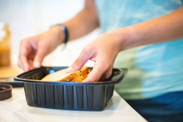 istock Millennial Female in Kitchen Preparing Meal Using Plastic Containers Photo Series 1317129818