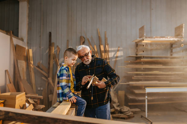 istock Boy with grandpa at carpenter workshop 1317131081
