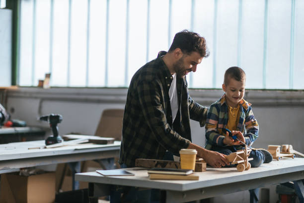 istock Dad showing son wooden toy that he made in workshop 1317131512