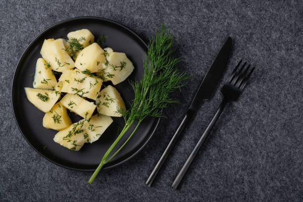 istock Boiled potatoes and dill on a black plate on a dark background 1317131522