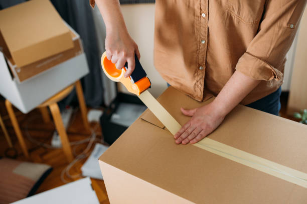 istock Moving out: Anonymous Plus Size Woman Sealing up a Cardboard Box with a Duct Tape (Horizontal) 1317133480