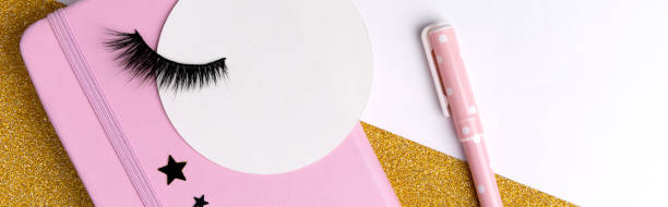 istock Creative composition with notepad and eyelashes on pink golden glitter background 1317133815