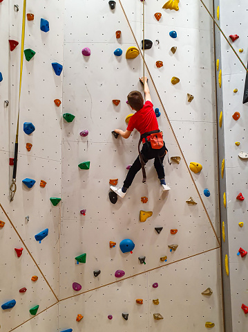 Young boy is climbing with top rope on a climbing wall, Brandbergen, Stockholm county