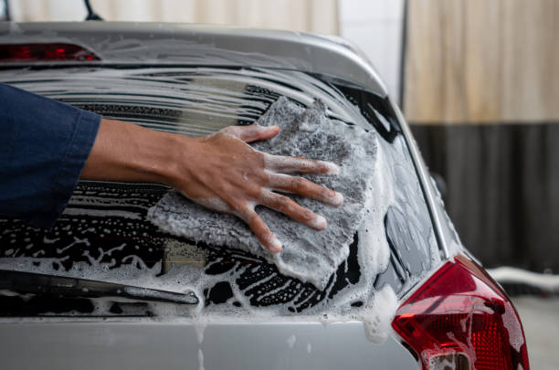 istock Close-up on a man working at a car wash cleaning the rear windshield 1317136955