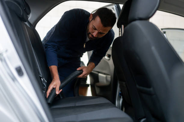 istock Man working at a car wash vacuuming the vehicle interior 1317137172
