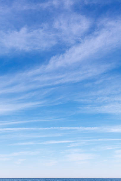beautiful sky over the sea with cirrus clouds. horizon line - blue vertical color image photography imagens e fotografias de stock