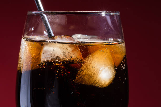 istock A glass of cola beverage with a salt. On a red background 1317138452