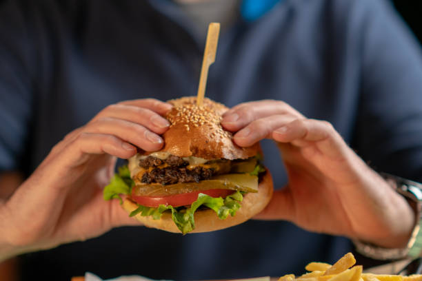 istock Man holding a tasty hamburger 1317139176