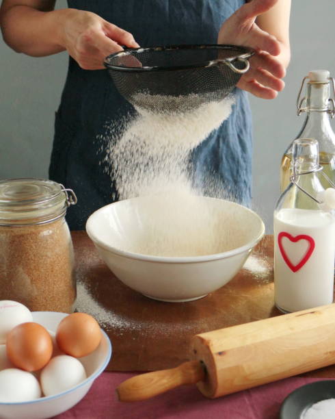 istock chef woman is sifting flour. Home coking 1317143347