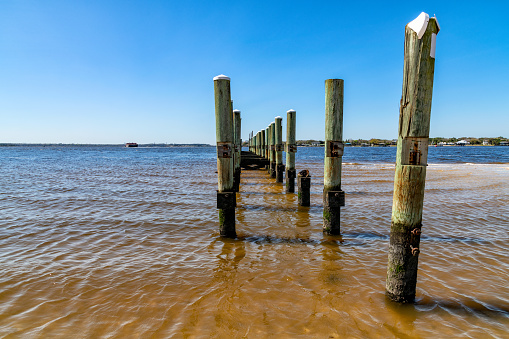 The pylons that, at one time, supported a pier, now broken, weathered and in disrepair located along the sea channel leading to Jacksonville, Florida along the Atlantic coast.