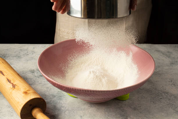 istock chef woman is sifting flour. Home coking 1317143751