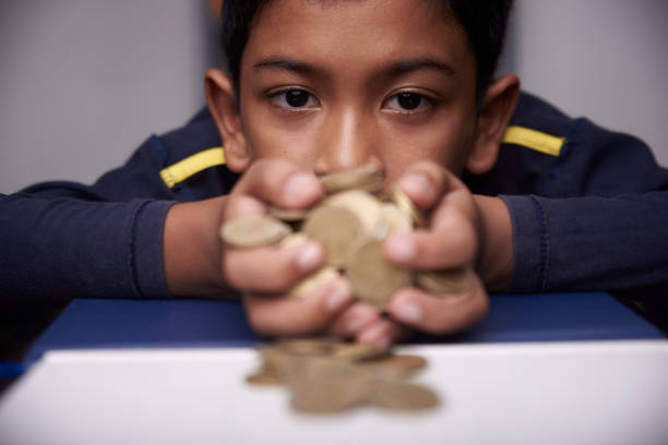 istock Boys holding coins on the table 1317144580