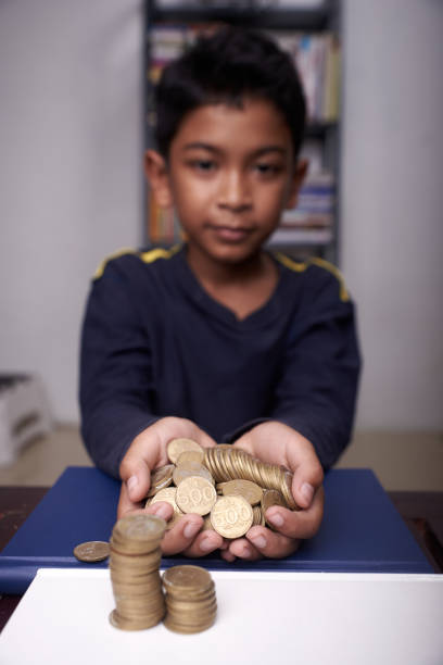 istock Boys holding coins on the table 1317144733