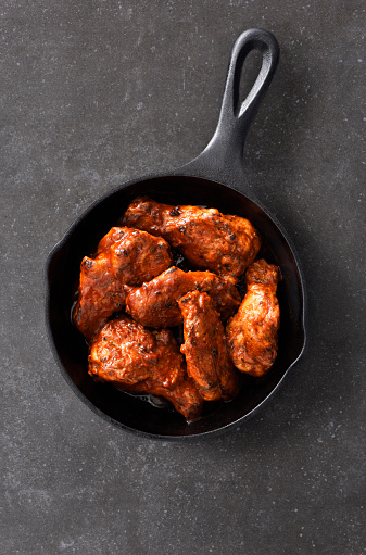 Spicy chicken wings in a black cast iron skillet