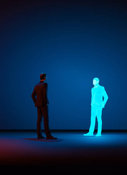 男はホログラムで作られた自分自身のデジタルクローンを見ます - クローン ストックフォトと画像