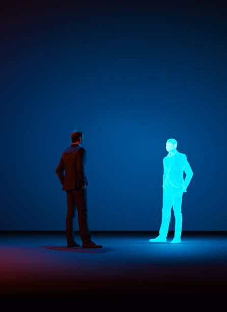 Man looks at a digital clone of himself made with a hologram Man stands in a room looking at a clone or avatar of himself. The clone is shown as a hologram. Concept image of future living where cloning becomes normal. cloning stock pictures, royalty-free photos & images