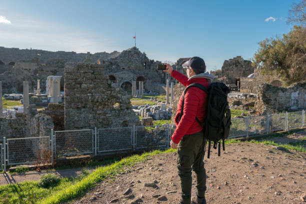 istock Man traveling alone taking photo with smartphone in Side Turkey 1317150204