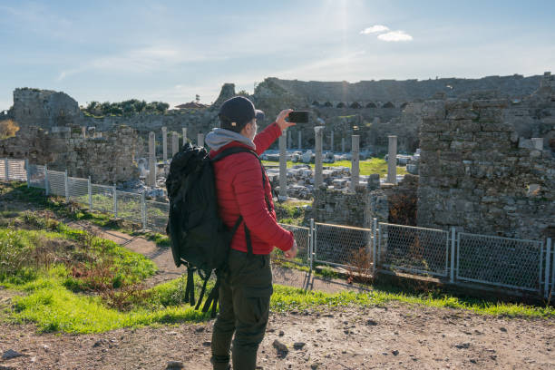 istock Man traveling alone taking photo with smartphone in Side Turkey 1317150236