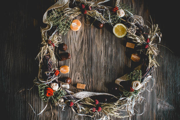istock Creative Christmas wreath with sweets. An unusual idea for a holiday home decor. Natural interior decor on wooden background. 1317151917