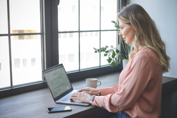 istock attractive middle aged woman working in the office ( with laptop) 1317153176