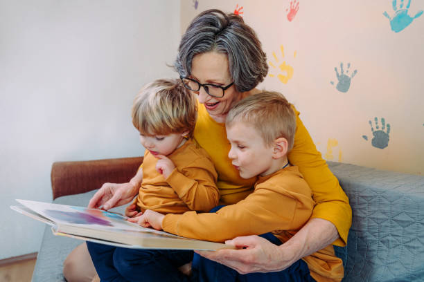 babcia bawiąc się razem z wnukami - grandmother reading child grandson zdjęcia i obrazy z banku zdjęć