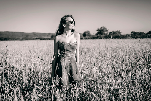 Young woman in the wheat field enjoying a sunny day