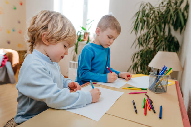 istock Two brothers drawing sitting at the table 1317154574