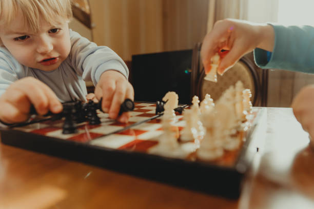 istock Two brothers learning play chess in the room 1317155310