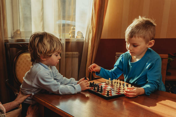 istock Two brothers learning play chess in the room 1317155381