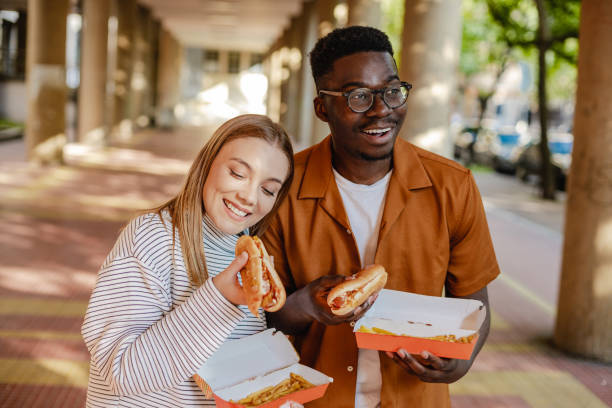istock Young people are eating hot dog and walking 1317157701