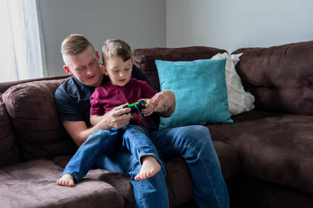 istock Father teaches his young son to play video games 1317160344