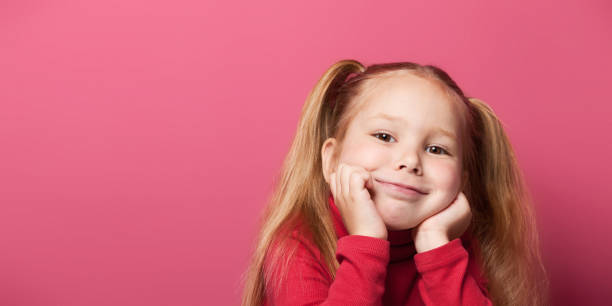 retrato de una linda niña sonriente de 6 años aislada sobre fondo rosa - 4 5 years fotografías e imágenes de stock