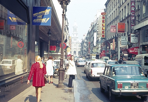 Paris, Il de France, France, 1978. Street scene with pedestrians, traffic, shops and buildings in Paris.