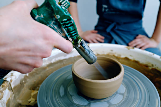 istock Drying finished ceramic bowl with industrial hot air gun. Ceramics workshop concept 1317163411