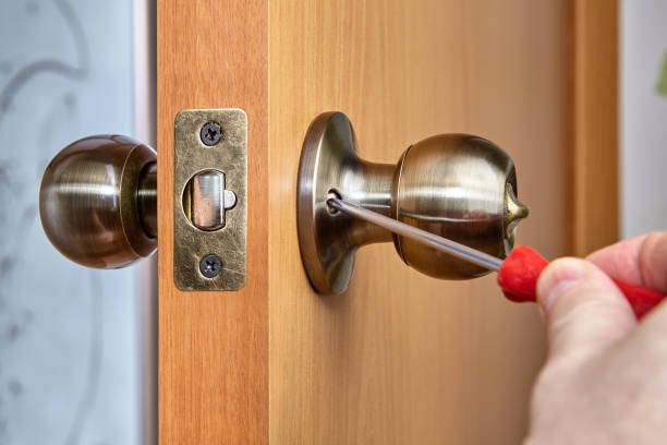 istock Joiner uses screwdriver to secure both handle sides to door. 1317167330