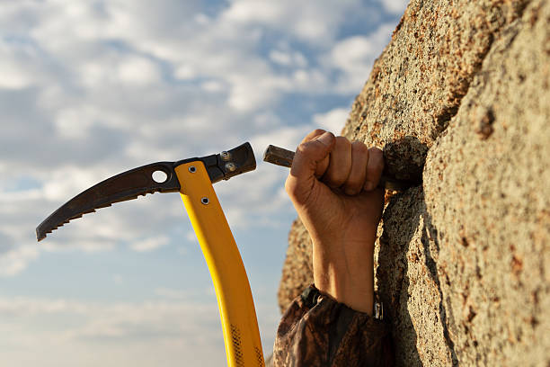 istock Hands rock-climber hammering in hook rock 131716987