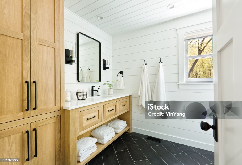 Contemporary Country Home Cabin Bathroom Design with Vanity and Linen Storage A contemporary modern bathroom design for a country home cabin. featuring a  classic freestanding vanity and linen storage cabinet. Bathroom Stock Photo
