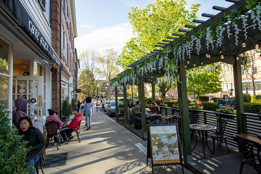 Princeton, USA - May 1, 2021. People dining outdoor or walking on sidewalk in downtown Princeton, New Jersey, USA.